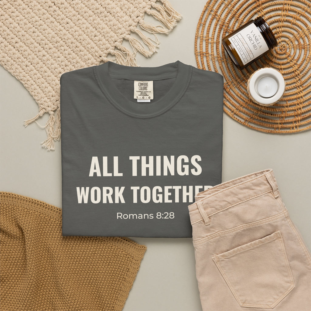 All Things Work Together Romans 8:28 tee in pepper, folded flat lay mockup