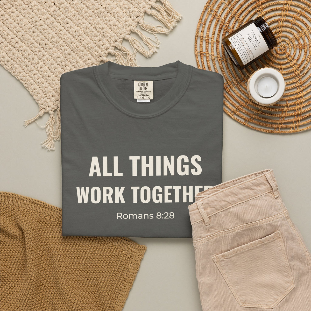 All Things Work Together Romans 8:28 tee in pepper, folded flat lay mockup