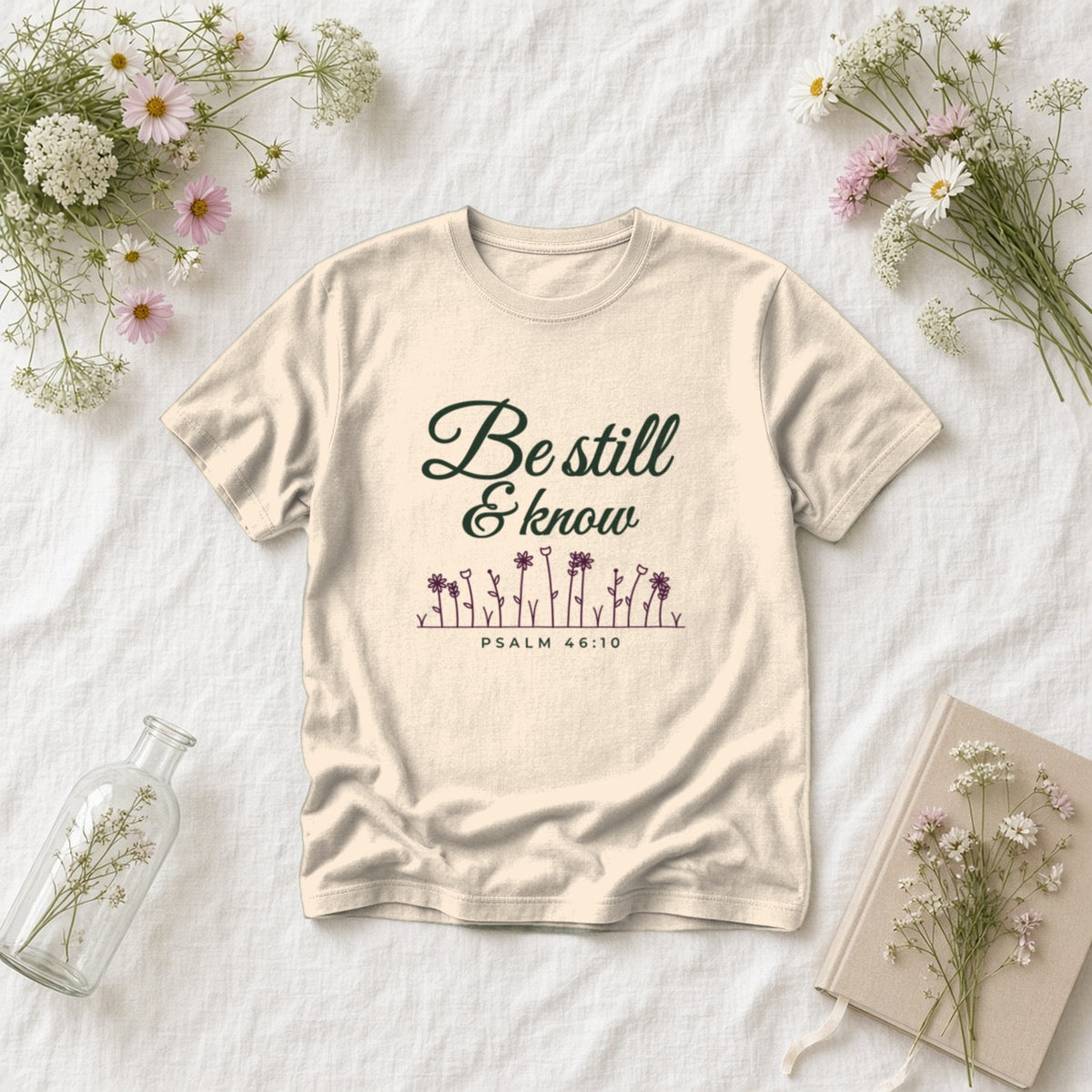Be Still & Know Wildflower Psalm 46:10 Christian tee in ivory, styled flat lay