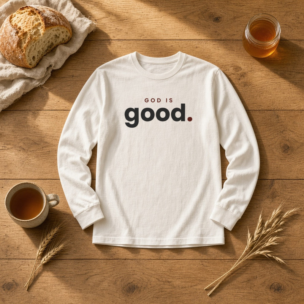 God Is Good Christian long sleeve tee in white, styled flat lay