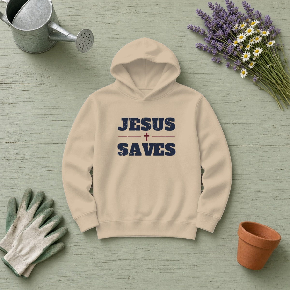 Jesus Saves Christian hoodie in sand, styled flat lay