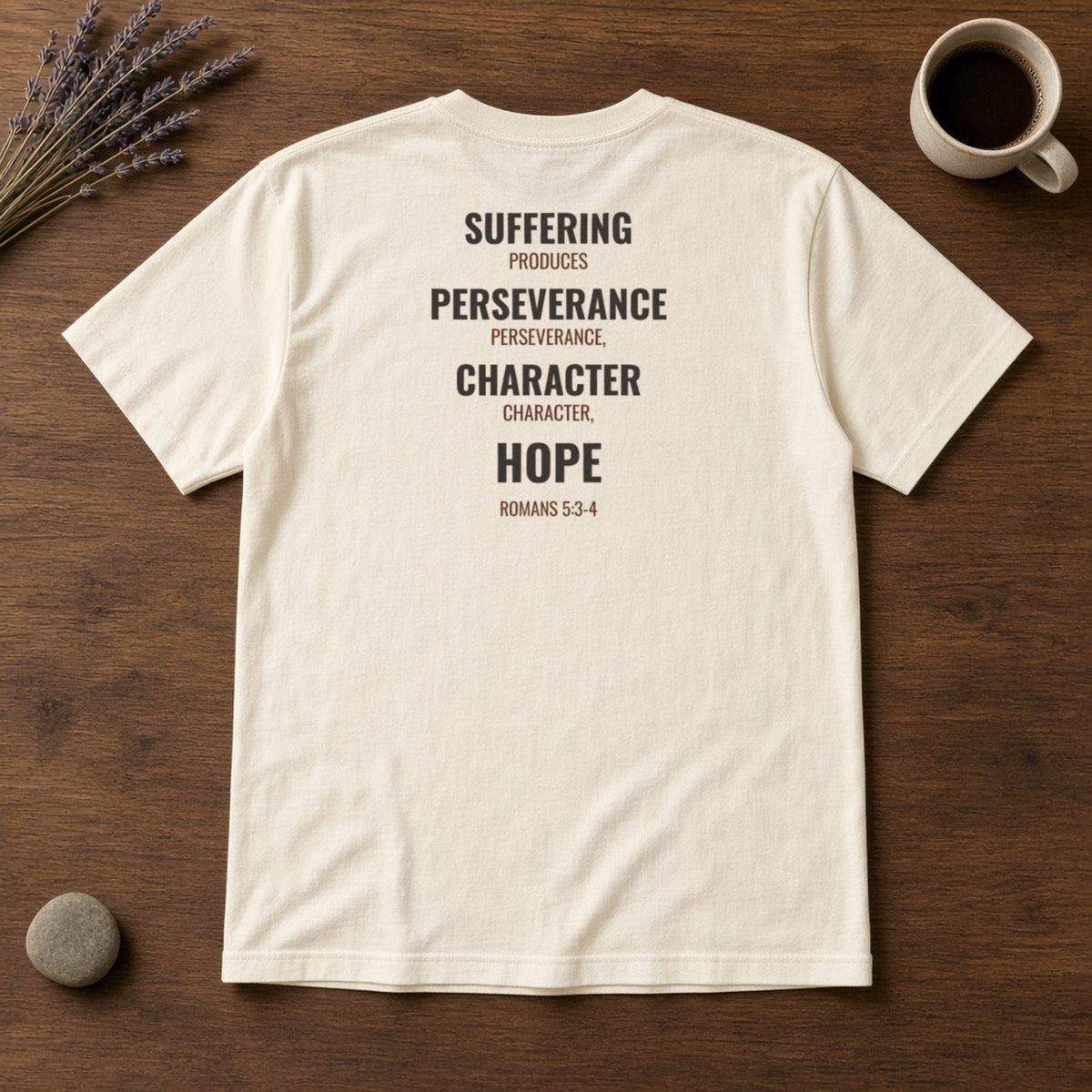 Suffering Produces Hope Romans 5:3-4 ivory tee, flat lay (back view)