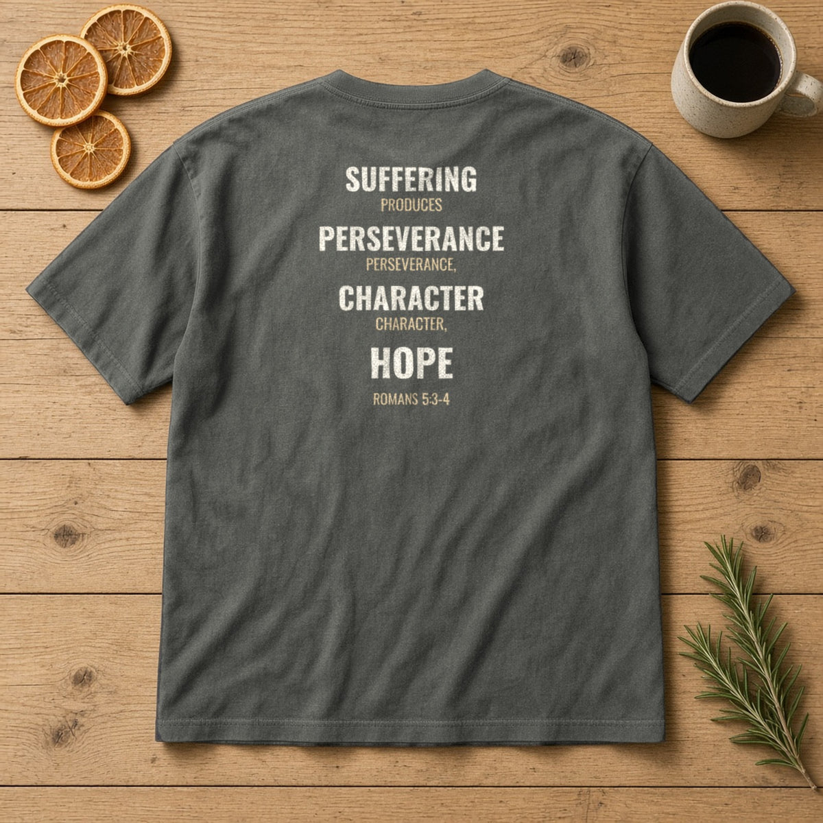 Suffering Produces Hope Romans 5:3-4 pepper tee, flat lay (back view)